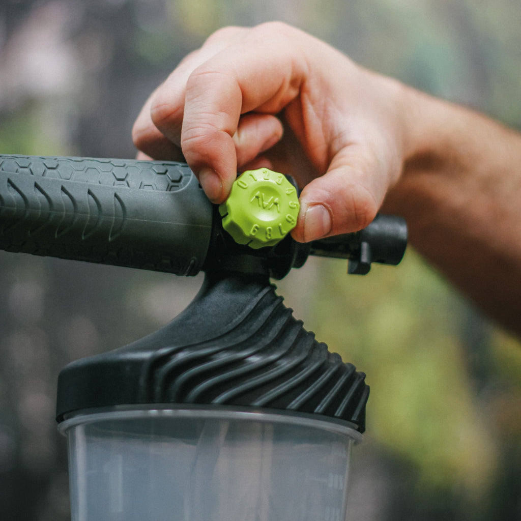 Close-up of a thumb and forefinger adjusting the green numbered dial on an AVA Premium Foam Cannon to regulate detergent flow.