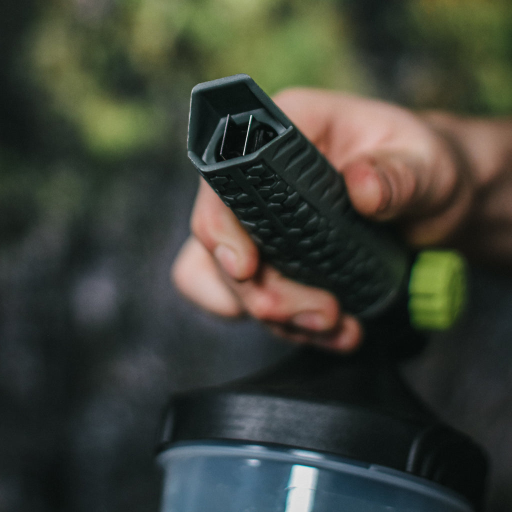 A close-up of a hand adjusting the black nozzle of a premium foam cannon to set the spray angle.
